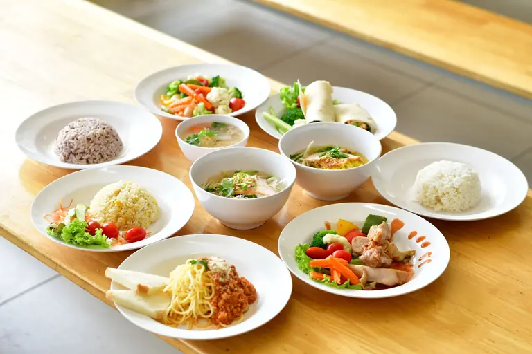 Assorted Asian cuisine displayed on a wooden table. Ideal for food enthusiasts.