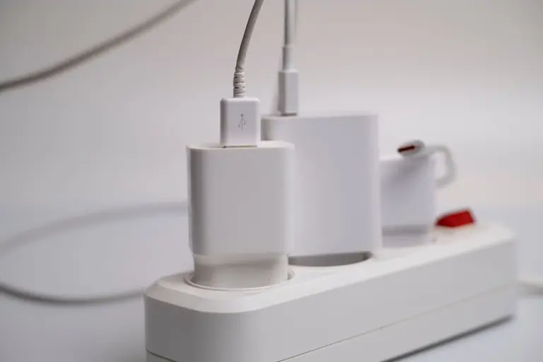Minimalist composition of electronic device chargers connected to a power strip indoors.