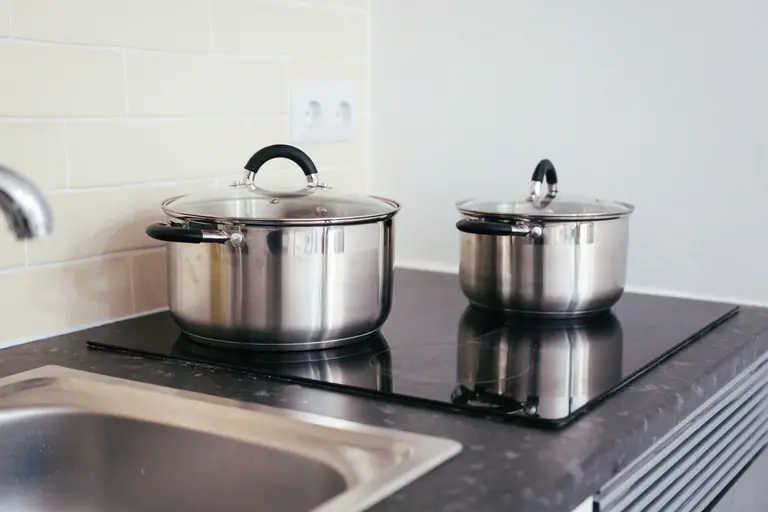 Contemporary kitchen setup with stainless steel pots on an induction stove.