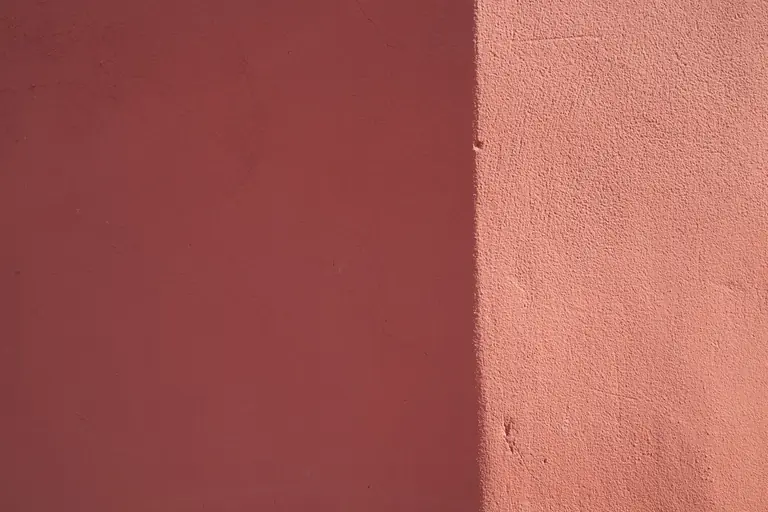 a close up of a pink wall with a clock on it
