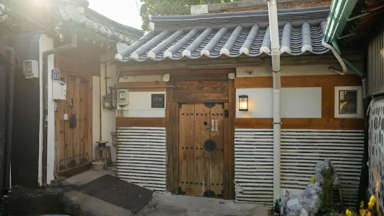 a small wooden building with a white roof