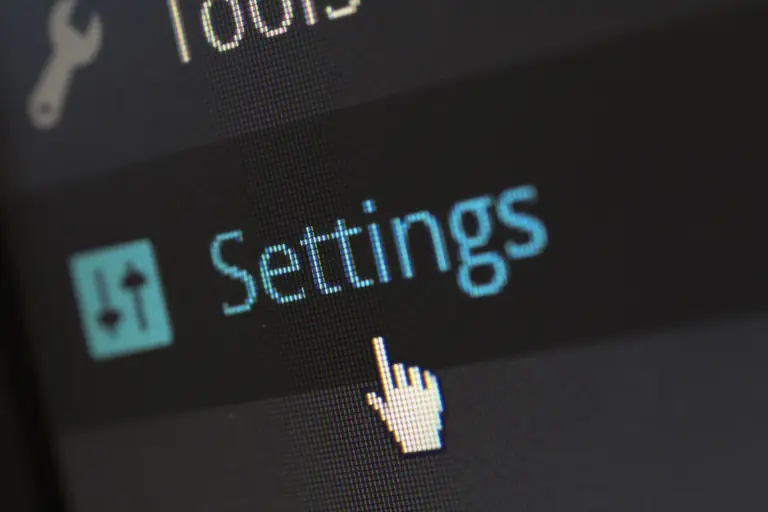 A close-up photo of a computer screen showing the settings button with a cursor hovering over it.