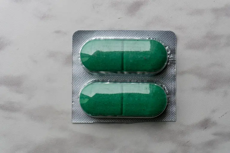 Two green pills in a silver blister pack