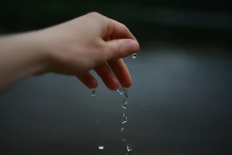 A hand is dropping water.