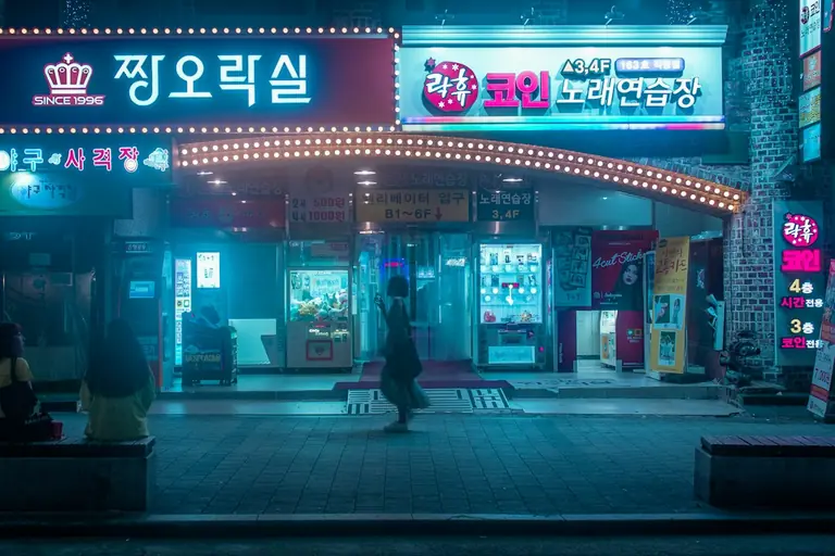 person carrying bag walking in front of store