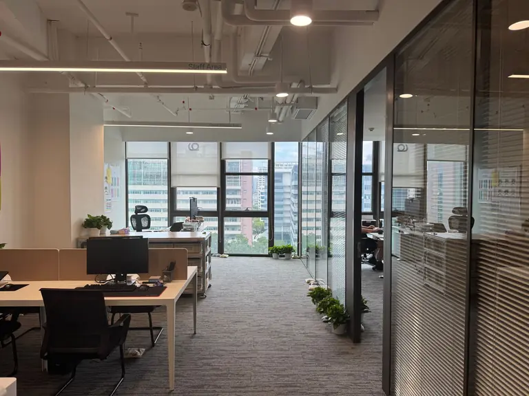 Bright, modern office interior with large windows and open workspace design.