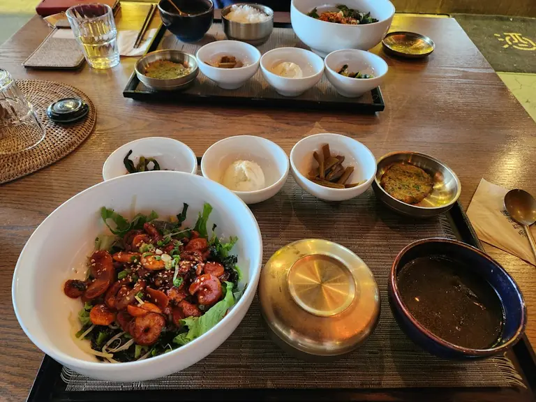 A wooden table topped with bowls of food