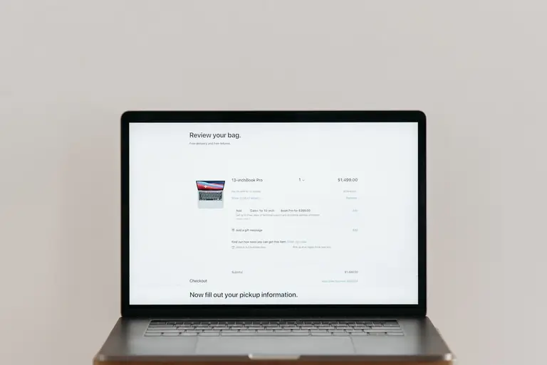 Minimalist laptop showing an online checkout screen on a white background, ideal for tech context.