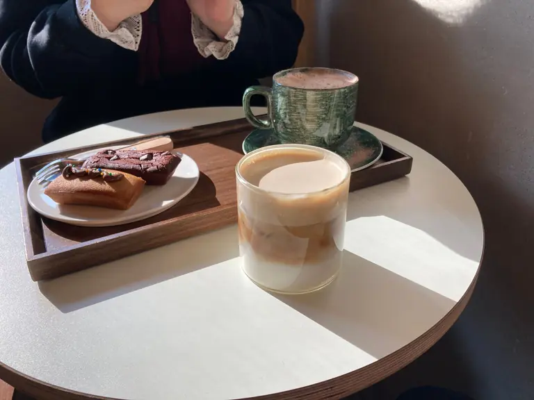 Warm light over a café table featuring coffee and pastries, perfect for a relaxing moment.