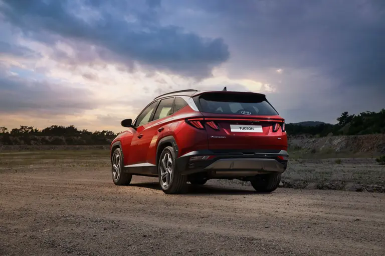 Red Hyundai SUV on a dirt road during sunset, showcasing its offroad capability.