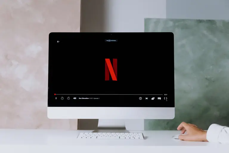 A minimalist workspace scene featuring a desktop displaying a streaming service, ideal for modern lifestyle themes.