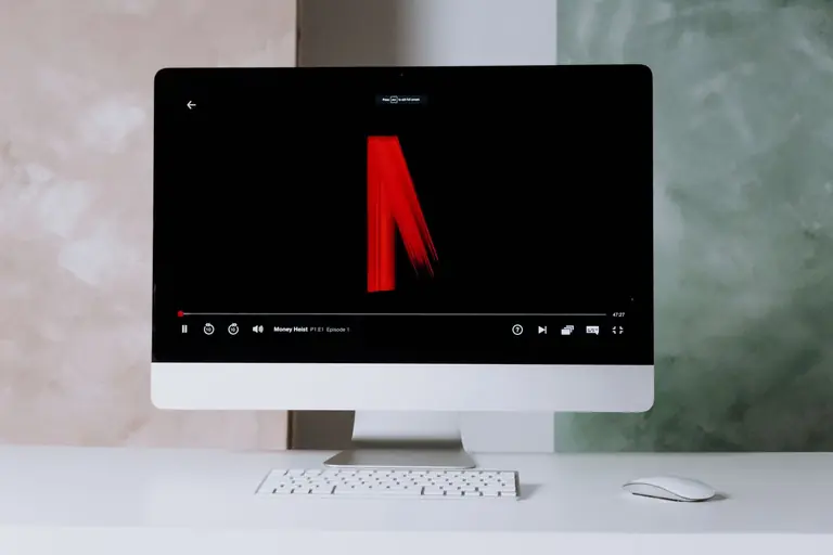 Modern desktop setup featuring streaming on a sleek monitor with keyboard and mouse.