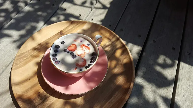 red and white ceramic mug on brown wooden round table