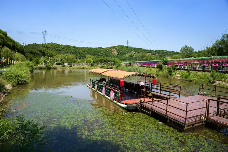 A boat waits at a dock on a calm lake.