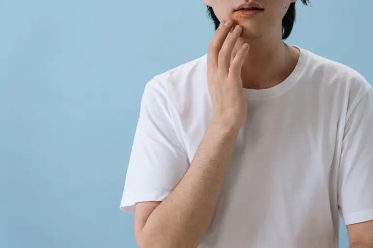 Close-up of a man touching his face showing signs of a skin condition or allergy.