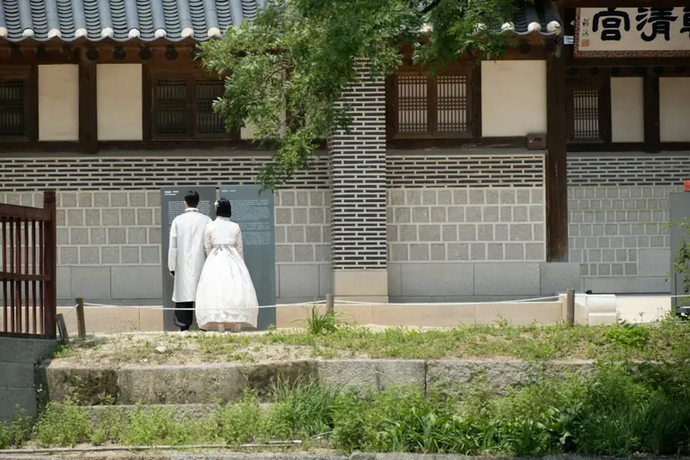 a man and a woman standing in front of a building