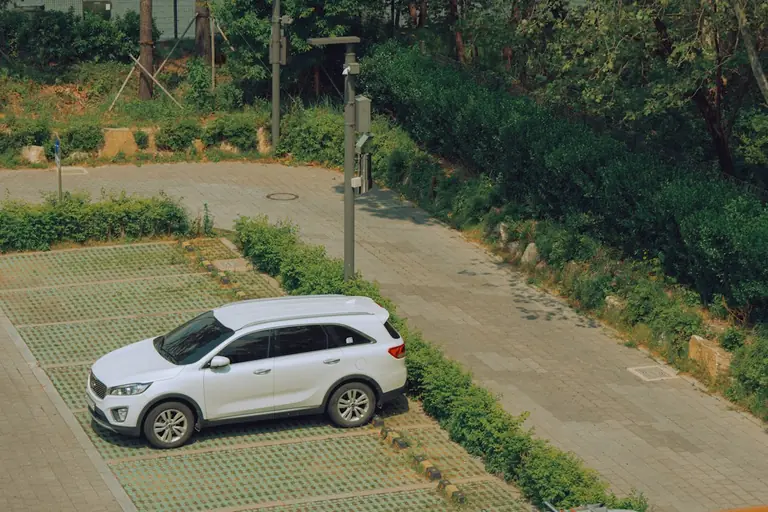 A white car is parked in an empty lot.